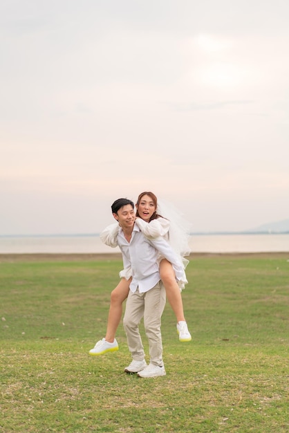 Heureux jeune couple asiatique en vêtements de mariée et de marié prêt à se marier et à célébrer le mariage