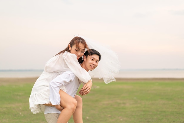 Heureux jeune couple asiatique en vêtements de mariée et de marié prêt à se marier et à célébrer le mariage