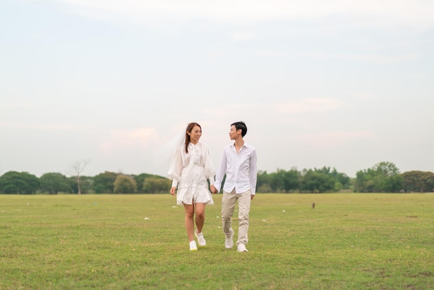 Heureux jeune couple asiatique en vêtements de mariée et de marié