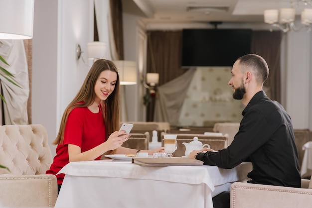 Heureux jeune couple assis et se parlant au restaurant