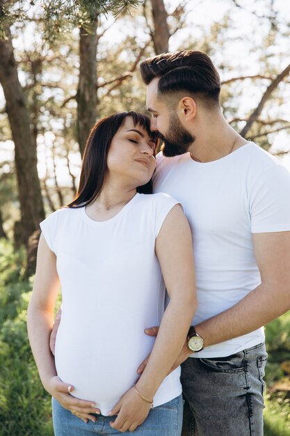 Heureux jeune couple attend bébé dans le parc de l&#39;été