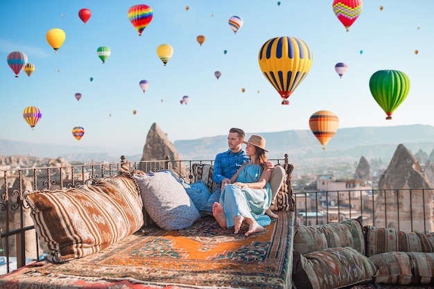 Heureux jeune couple au lever du soleil en regardant des ballons à air chaud en Cappadoce, Turquie