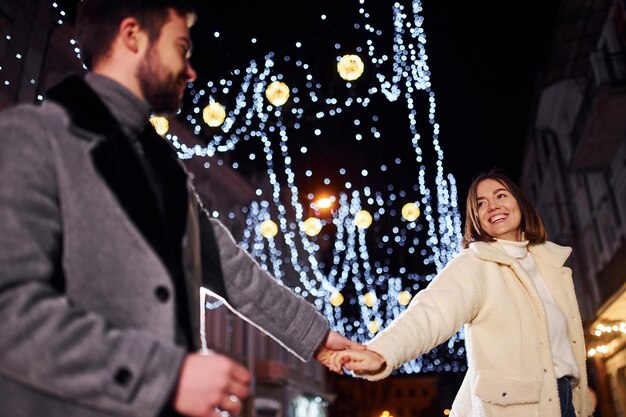 Heureux jeune couple célébrant le nouvel an à l'extérieur dans la rue