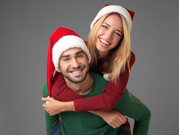 Heureux jeune couple en chapeaux de Santa