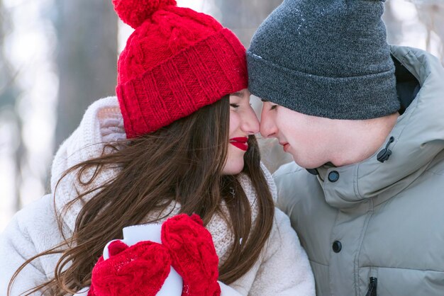 Heureux jeune couple en chapeaux tricotés à l'extérieur. Portrait d'amoureux.