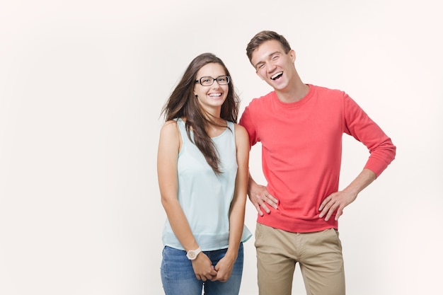 Heureux jeune couple charmant debout ensemble et en riant.