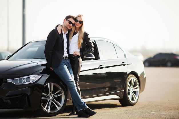 Heureux jeune couple choisit et achète une nouvelle voiture pour la famille.