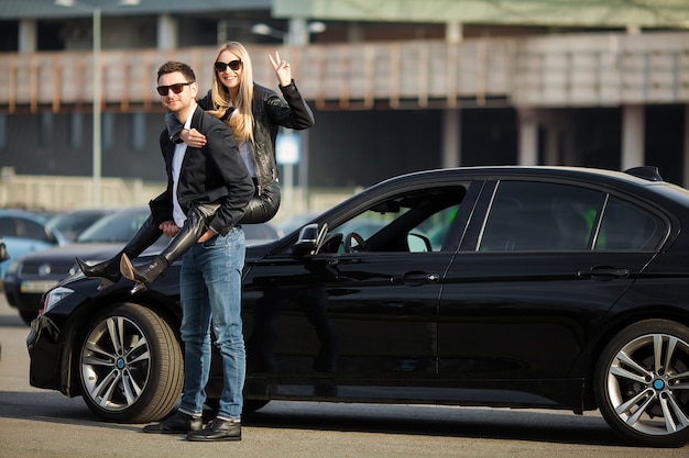 Heureux jeune couple choisit et achète une nouvelle voiture pour la famille