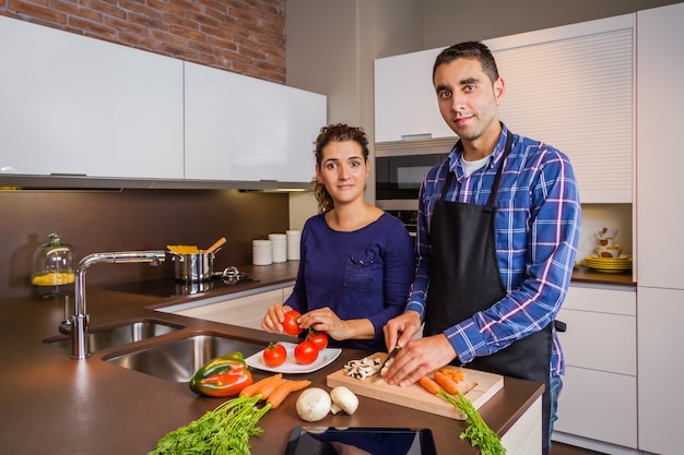 Heureux jeune couple dans une cuisine à domicile préparant des aliments sains pour le déjeuner. Concept de mode de vie familial moderne.