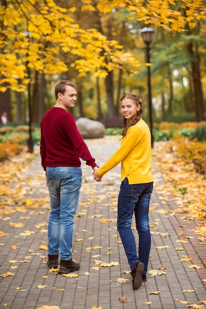 Heureux jeune couple dans le parc d'automne