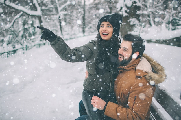 Heureux jeune couple dans le parc d'hiver