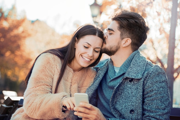 Heureux jeune couple dans la ville prenant selfie