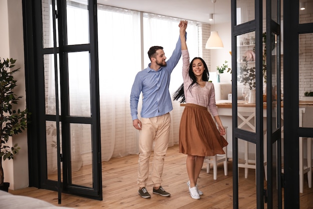 Heureux jeune couple dansant à la maison