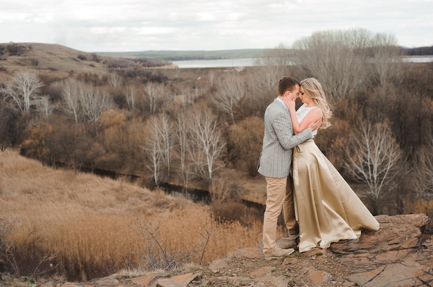 Heureux jeune couple embrassant au bord de la montagne