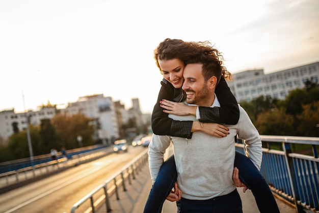 Heureux jeune couple embrassant en riant à la date. Les gens embrassent le concept amusant de bonheur.