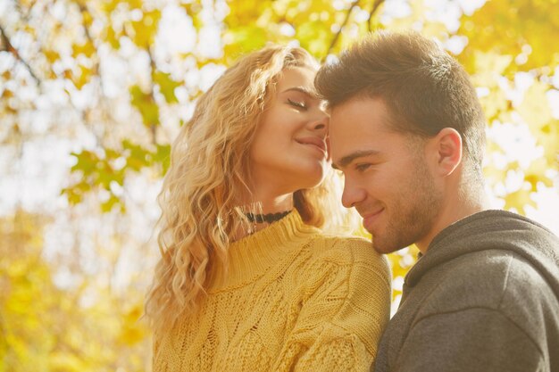 Heureux jeune couple à l'extérieur par une belle journée d'automne dans la forêt