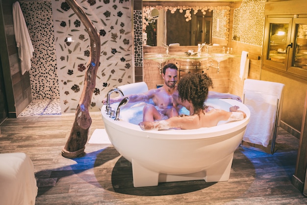 Heureux jeune couple interracial détendu appréciant leur auto dans le jacuzzi