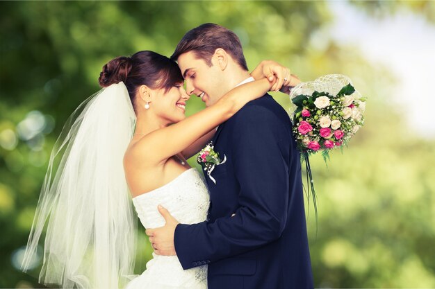 Heureux jeune couple juste marié dans un jardin verdoyant, bokeh