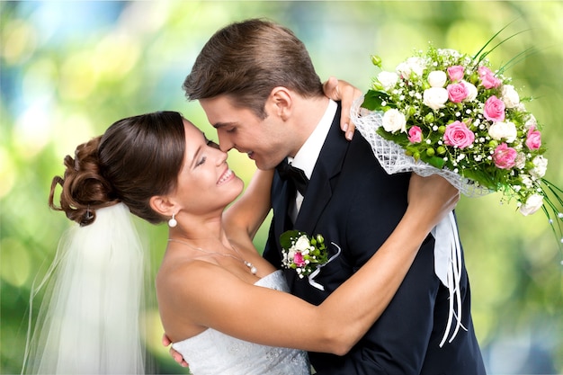 Heureux jeune couple juste marié avec des fleurs