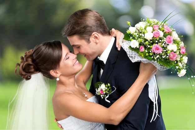 Heureux jeune couple juste marié avec des fleurs