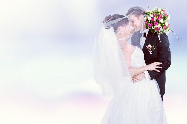 Heureux jeune couple juste marié avec des fleurs