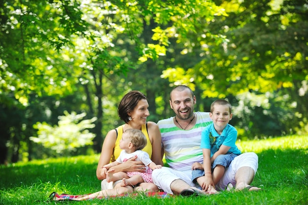 Heureux jeune couple avec leurs enfants s'amusent au beau parc en plein air dans la nature