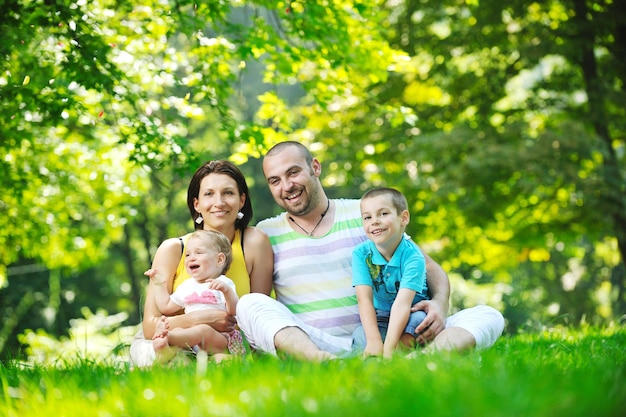 Heureux jeune couple avec leurs enfants s'amusent au beau parc en plein air dans la nature