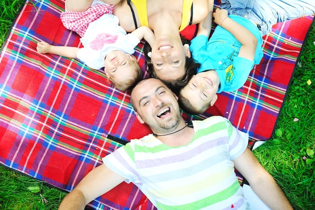 Photo heureux jeune couple avec leurs enfants s'amusent au beau parc en plein air dans la nature