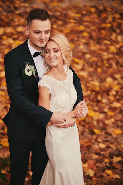 Heureux jeune couple marié dans le parc automne automne jaune doré