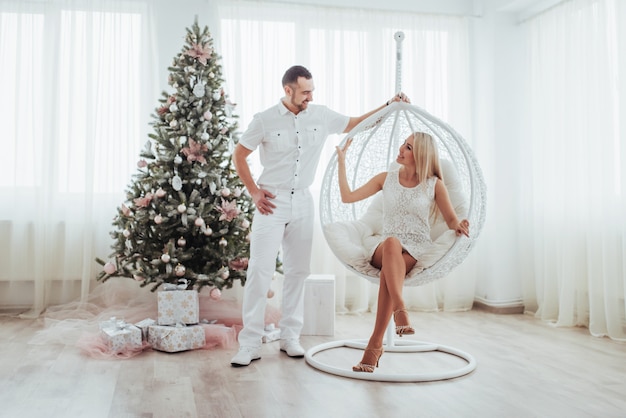 Heureux jeune couple à Noël, beaux cadeaux et arbre dans le