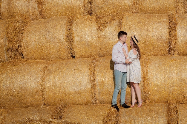 Heureux jeune couple sur la paille, concept de personnes romantiques, beau paysage, saison estivale.