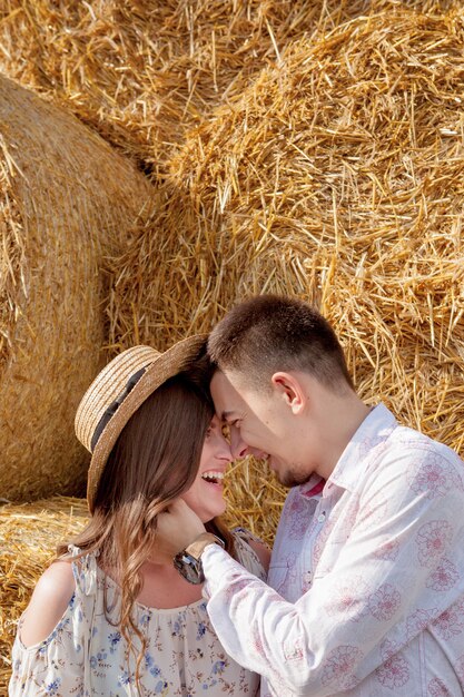 Heureux jeune couple sur la paille, personnes romantiques, beau paysage, saison estivale