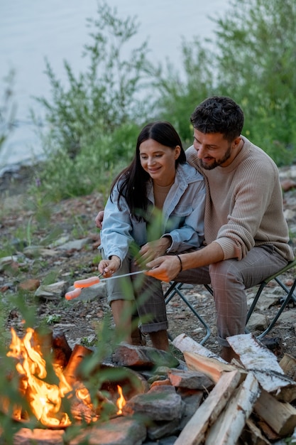 Heureux jeune couple passant du temps au feu de camp