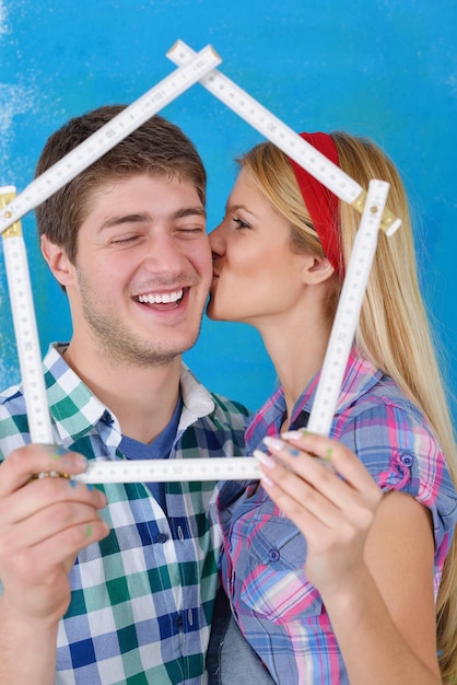 heureux jeune couple peint en vert et bleu le mur blanc de leur nouvelle maison