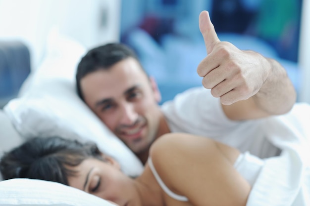 heureux jeune couple de personnes en bonne santé passe du bon temps dans leur chambre à coucher faire l'amour et dormir