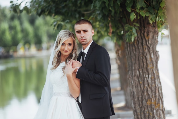 Heureux jeune couple pose pour les photographes le jour le plus heureux de sa vie.