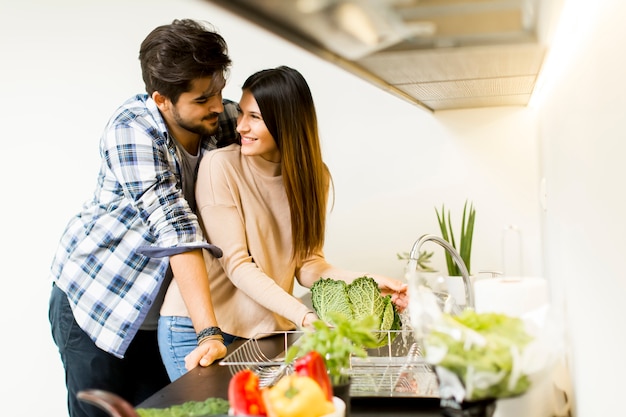 Heureux jeune couple préparant la nourriture dans la cuisine