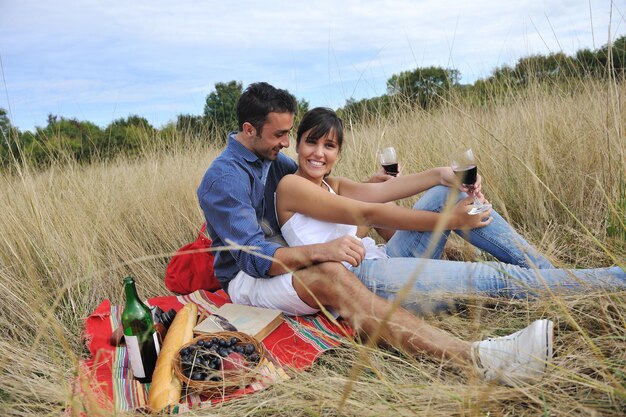 heureux jeune couple profitant d'un pique-nique à la campagne sur le terrain et passer du bon temps