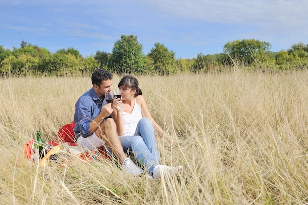 heureux jeune couple profitant d'un pique-nique à la campagne sur le terrain et passer du bon temps