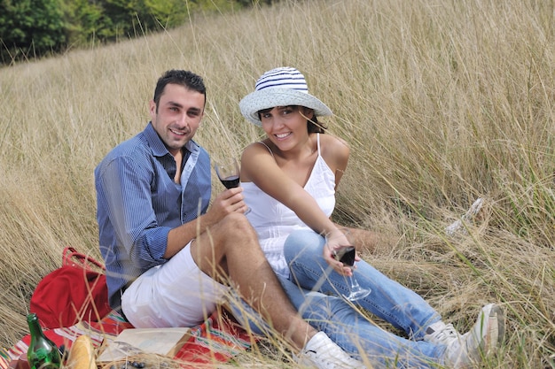 heureux jeune couple profitant d'un pique-nique à la campagne sur le terrain et passer du bon temps