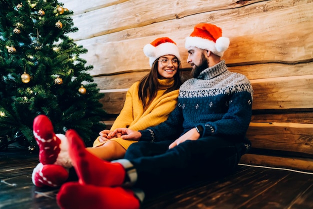 Heureux jeune couple profitant de vacances près de l'arbre de Noël