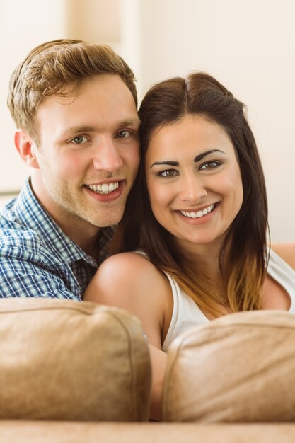 Heureux jeune couple reposant sur le canapé