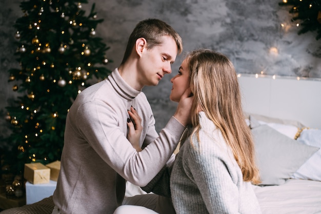 Heureux jeune couple restant au lit à la maison