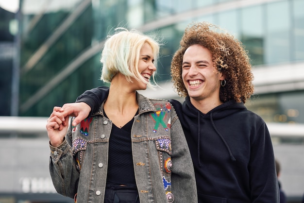 Heureux jeune couple rire en contexte urbain