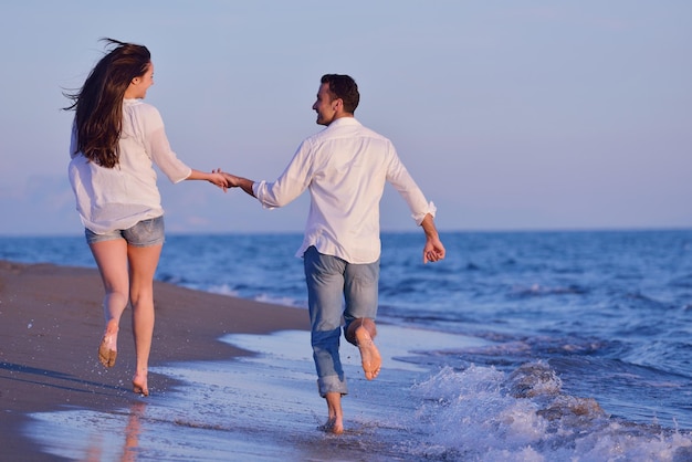 heureux jeune couple romantique amoureux s'amuser sur la belle plage à la belle journée d'été