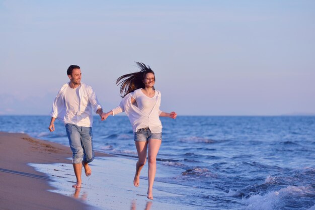 heureux jeune couple romantique amoureux s'amuser sur la belle plage à la belle journée d'été