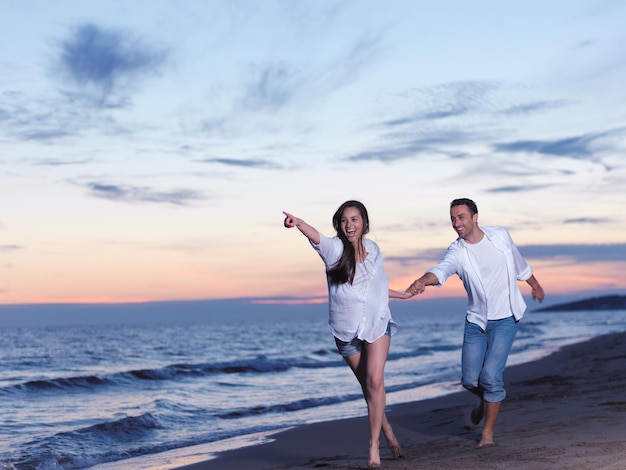 heureux jeune couple romantique amoureux s'amuser sur la belle plage à la belle journée d'été