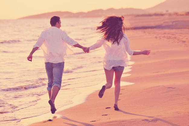 heureux jeune couple romantique amoureux s'amuser sur la belle plage à la belle journée d'été
