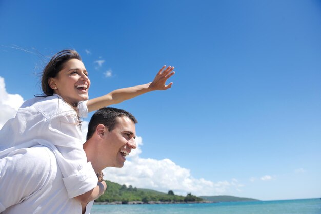 heureux jeune couple romantique amoureux s'amuser à courir et se détendre sur la belle plage