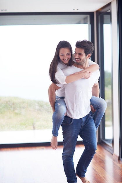 heureux jeune couple romantique s'amuser se détendre sourire à l'intérieur du salon de la maison moderne